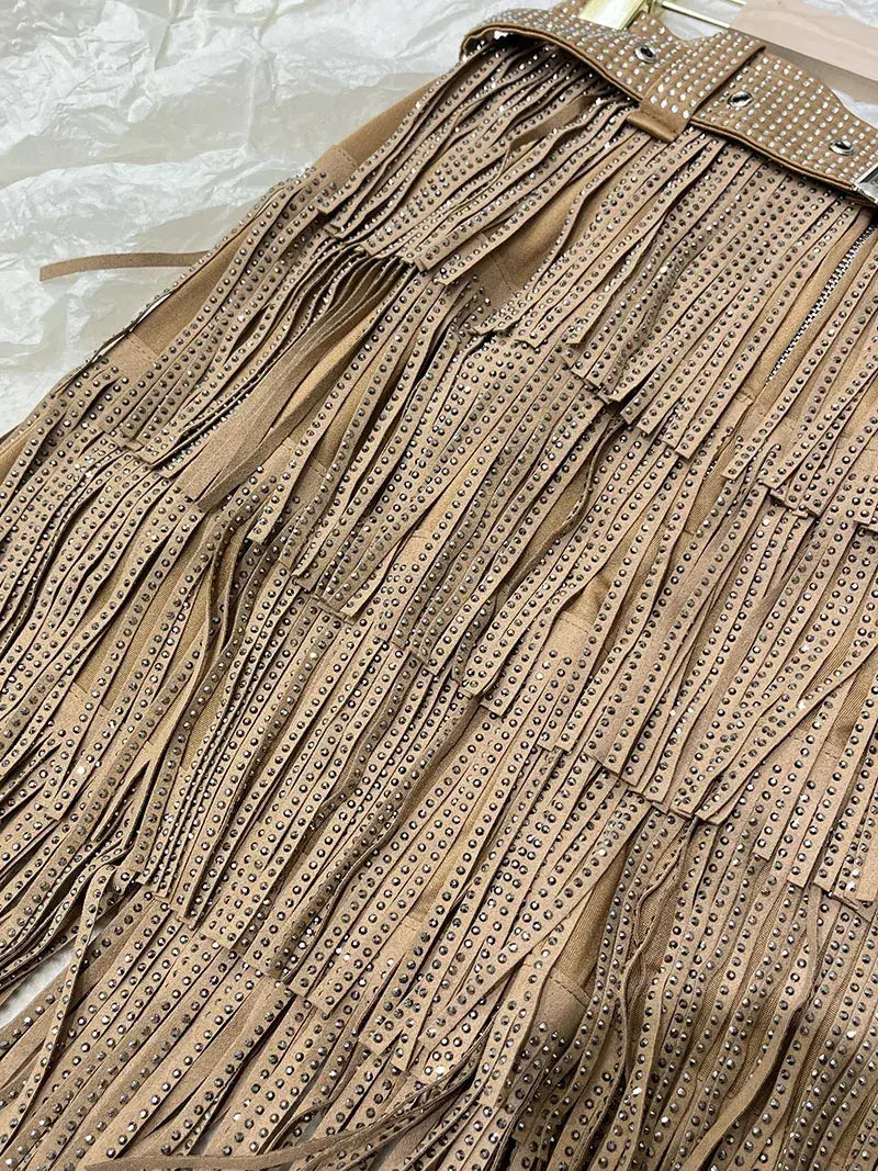 Mini-jupe taille haute en suède beige à franges en strass, avec des rangées de clous métalliques sur les franges et la ceinture