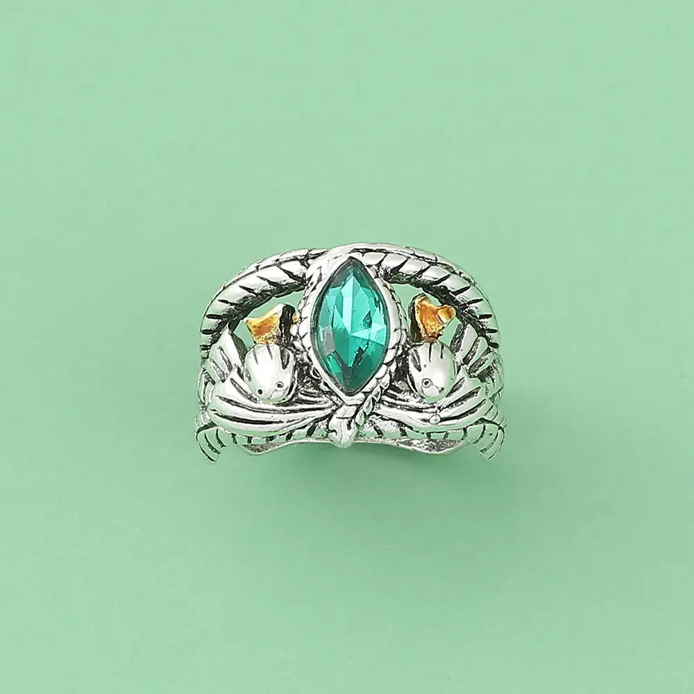Silberner Aragorn-Ring von Barahir mit einem zentralen tealfarbenen Marquise-förmigen grünen Kristalledelstein, flankiert von goldverzierten Vogelmotiven, sowie einer aufwendig gestalteten, geflochtenen Bandstruktur.