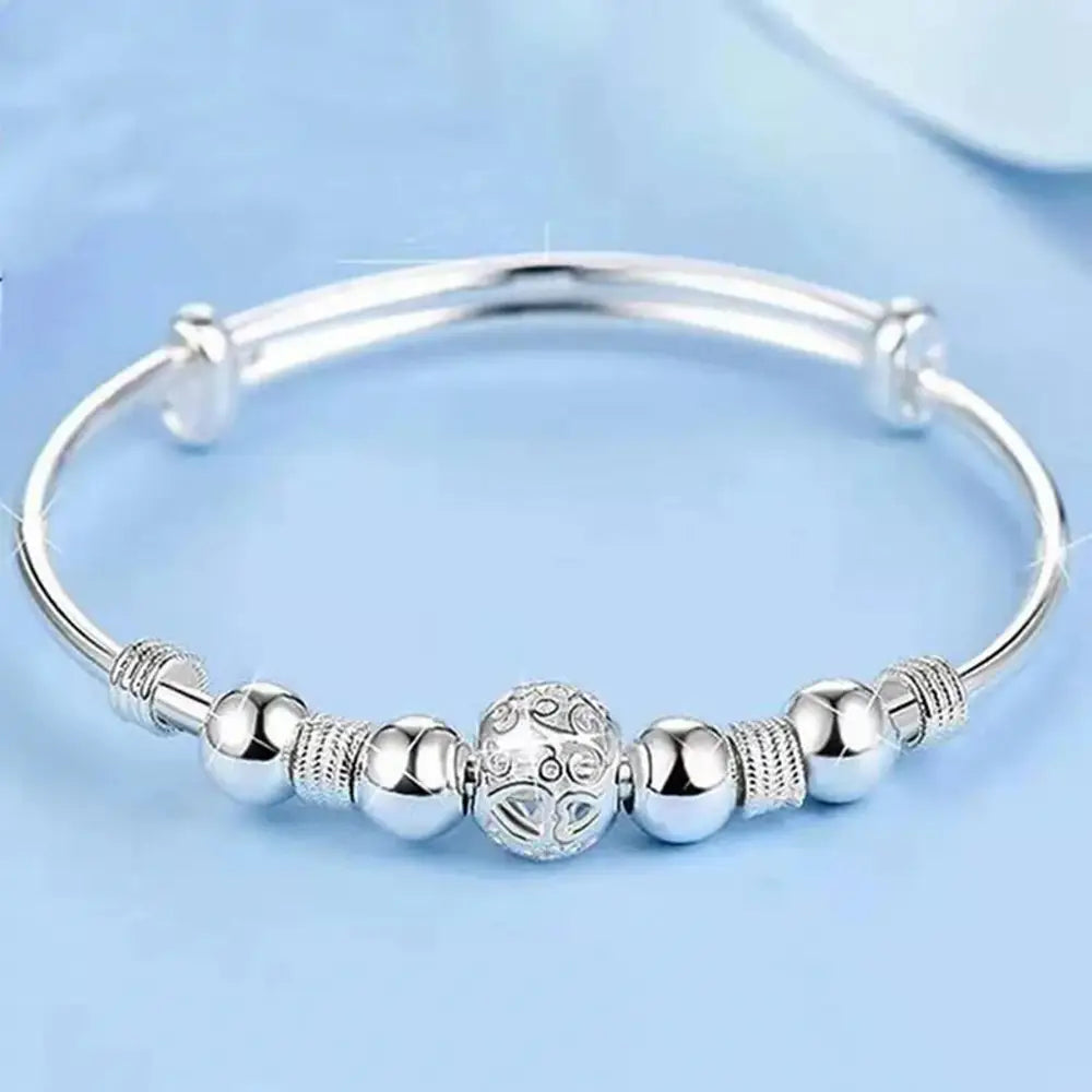 Sterling silver exquisite beaded adjustable bangle bracelet for women featuring a central ornate bead flanked by smooth spherical beads and textured connectors, ideal as a party gift.