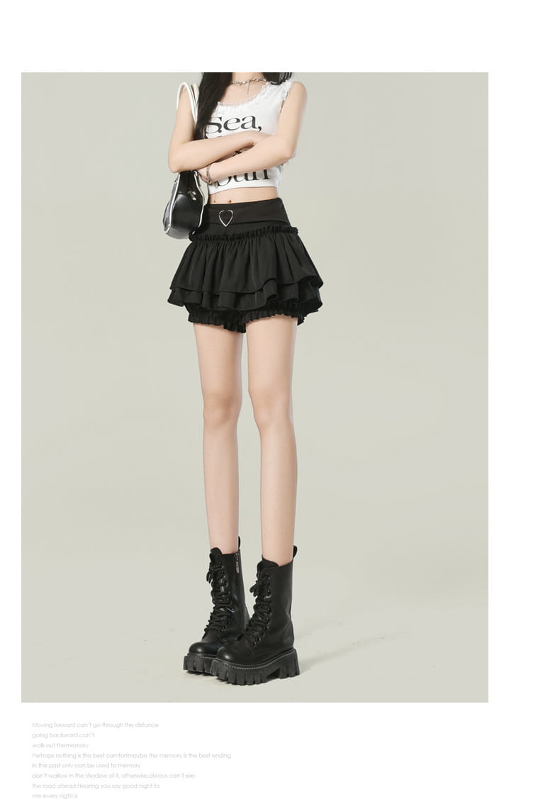 Black ruffled high waist mini skirt with a heart-shaped metal belt buckle showcasing Y2k style fashion.