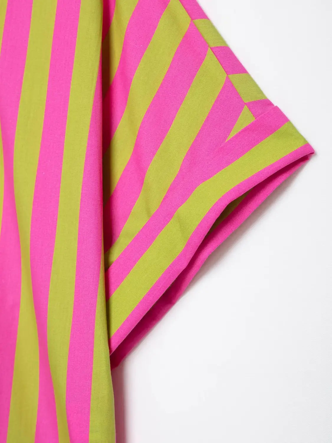 Ein leuchtend pinkfarbenes und lindgrünes Kurzarmhemd mit einem markanten diagonalen Muster.
