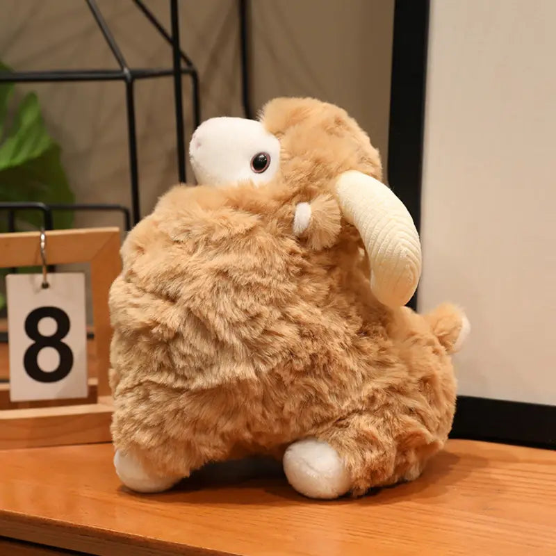 Plüschschaf-Geschmacktier im niedlichen Kawaii-Weichpuppen-Design mit flauschigem hellbraunem Plüschkörper, weißem Gesicht, Fesseln und geschwungenen Hörnern