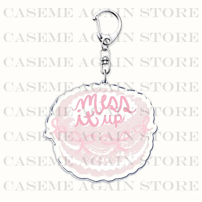 A pink and white scalloped-edge acrylic keychain with the phrase mess it up in cursive script designed as a Gracie Abrams anime fan gift.
