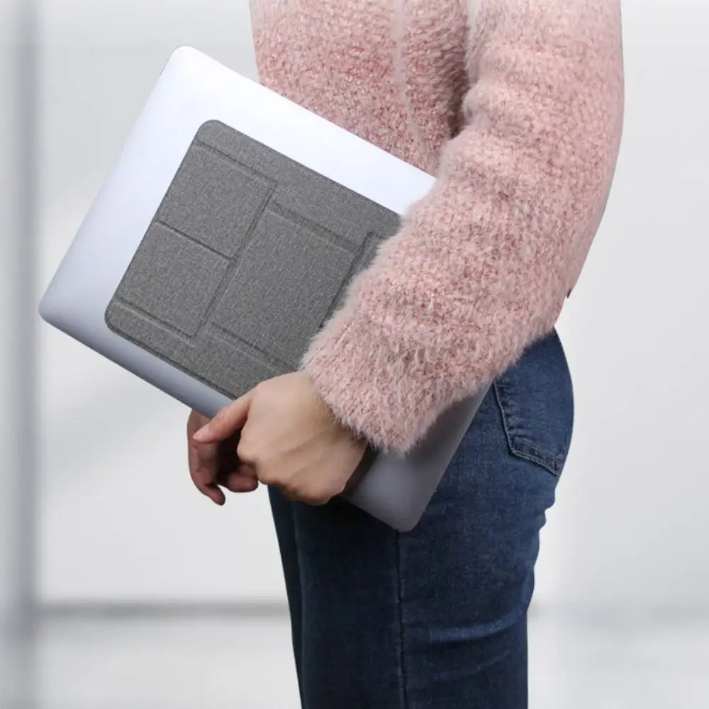 Grauer faltbarer Laptopständer mit einer strukturierten Stoffoberfläche und segmentiertem Design zur Unterstützung, geeignet für 12- bis 16-Zoll-Notebooks.