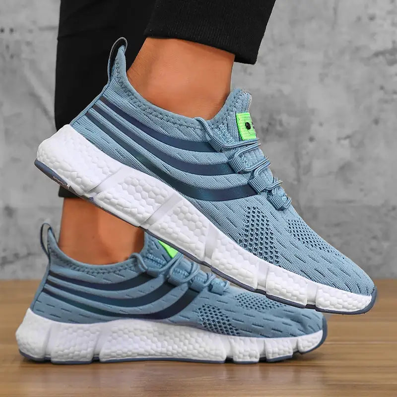 Baskets de sport décontractées en maille respirante pour hommes Zuuban en mesh bleu clair, avec des bandes bleu foncé et des accents vert néon sur la languette, avec une semelle texturée blanche.