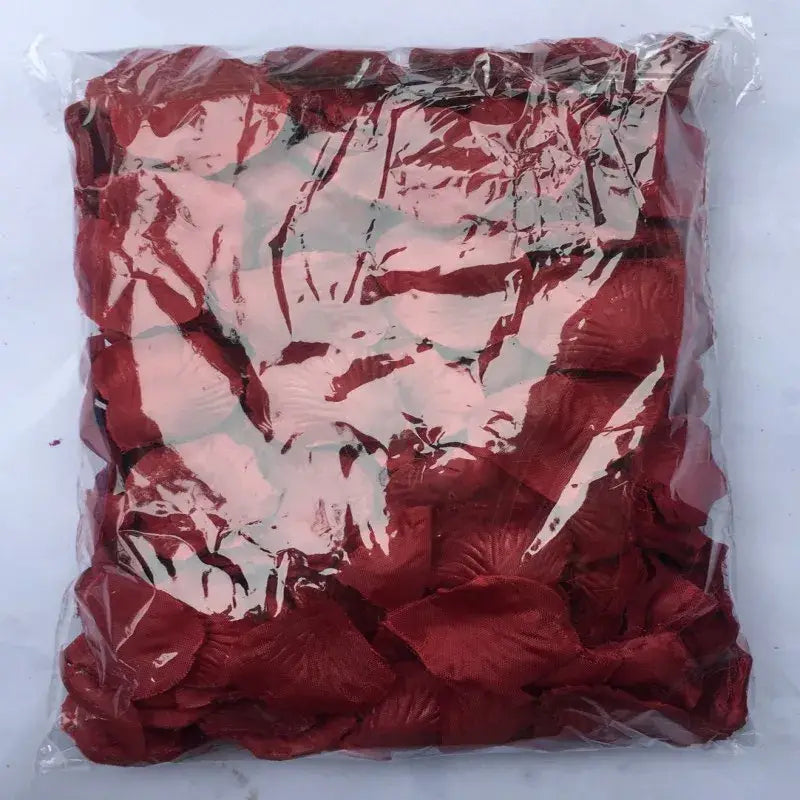 A package of vibrant red artificial rose petals sealed in clear plastic for wedding decor titled 5500 colorful rose petals.