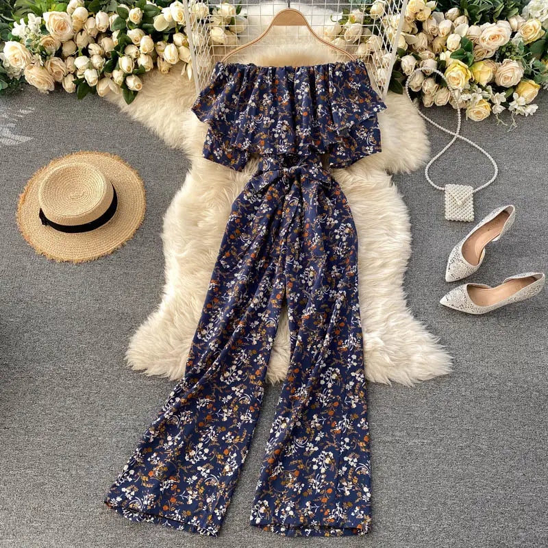 Enterizo de pierna ancha con estampado floral azul marino, escote tipo bardot, mangas con volante y cinturilla atada confeccionada con tejido ligero para un uso casual elegante.