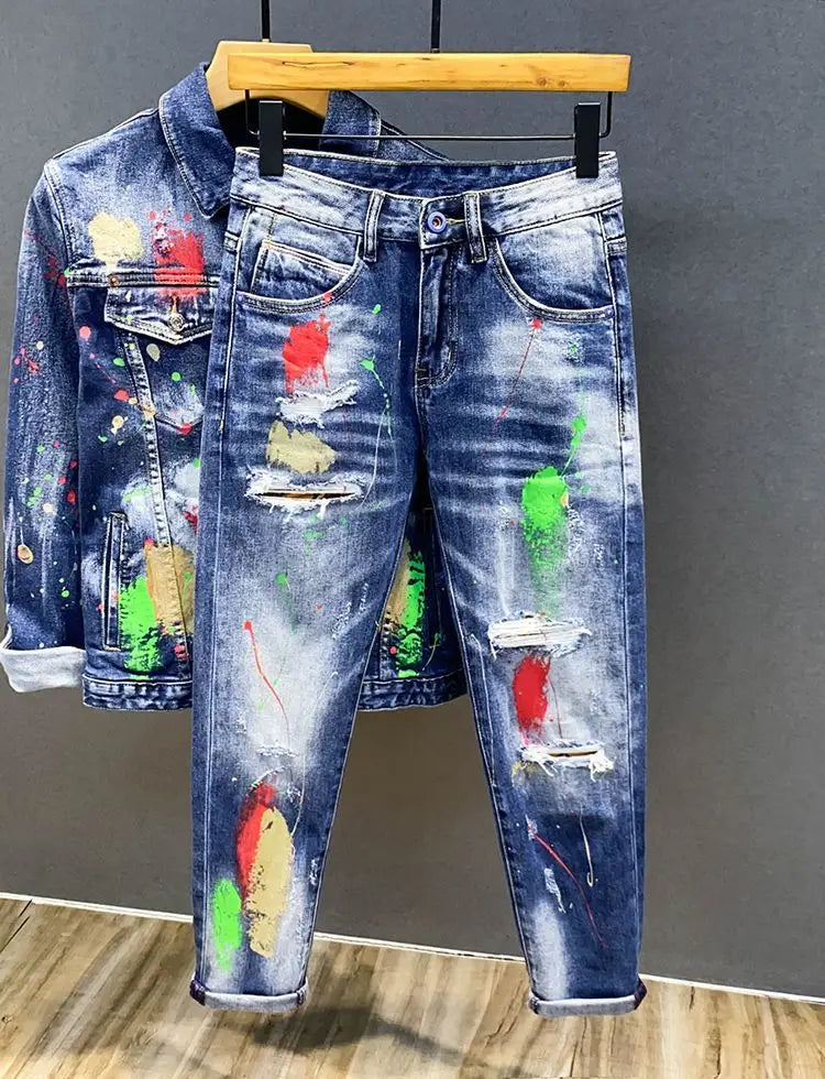 Jeans en denim bleu pour hommes avec un motif d’éclaboussures de peinture colorées et des détails déchirés.