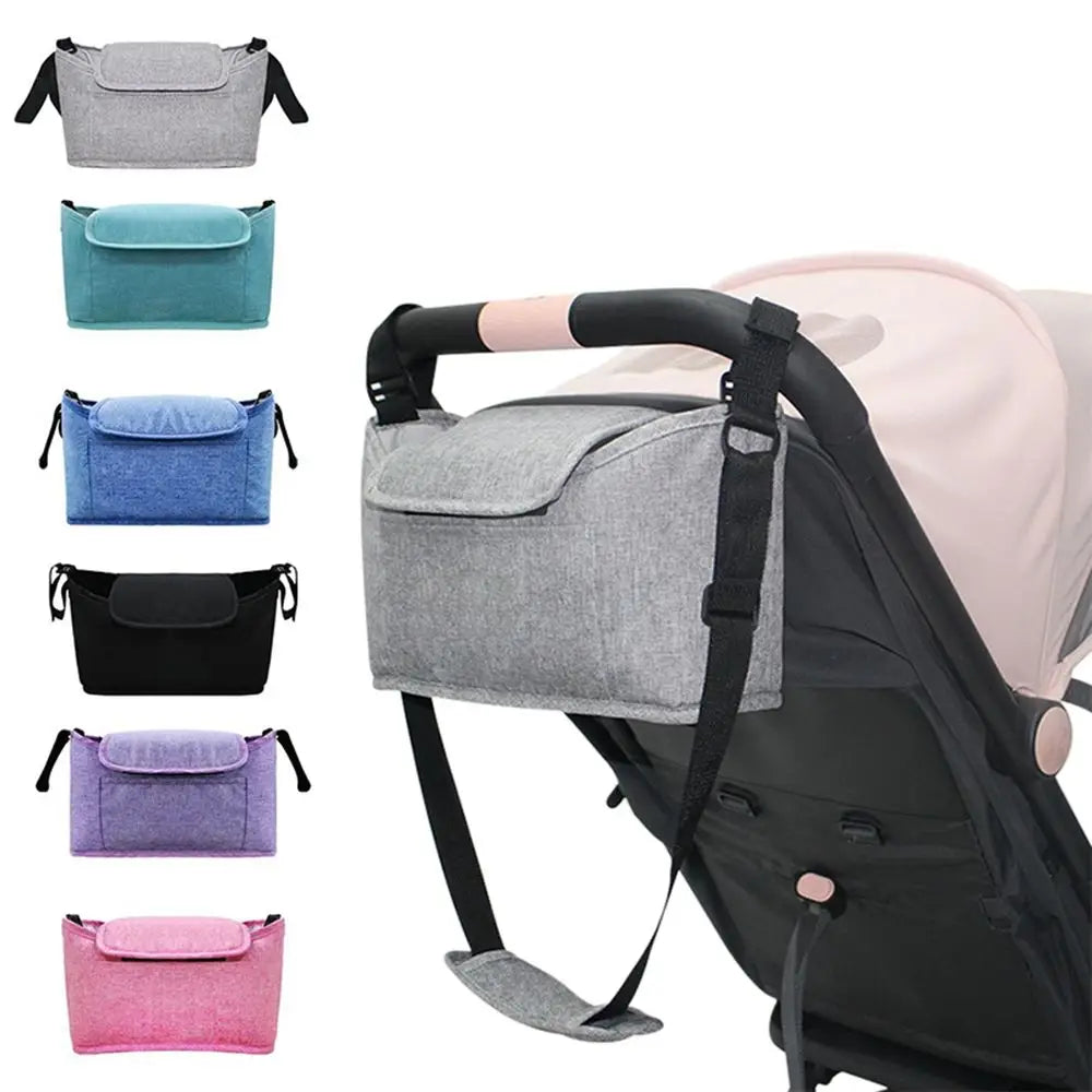 Kinderwagen-Organizer-Tasche aus grauem, strukturiertem Stoff mit schwarzen Trägern und einer Vordeklappentasche für universelle Kinderwagen-Aufbewahrung.