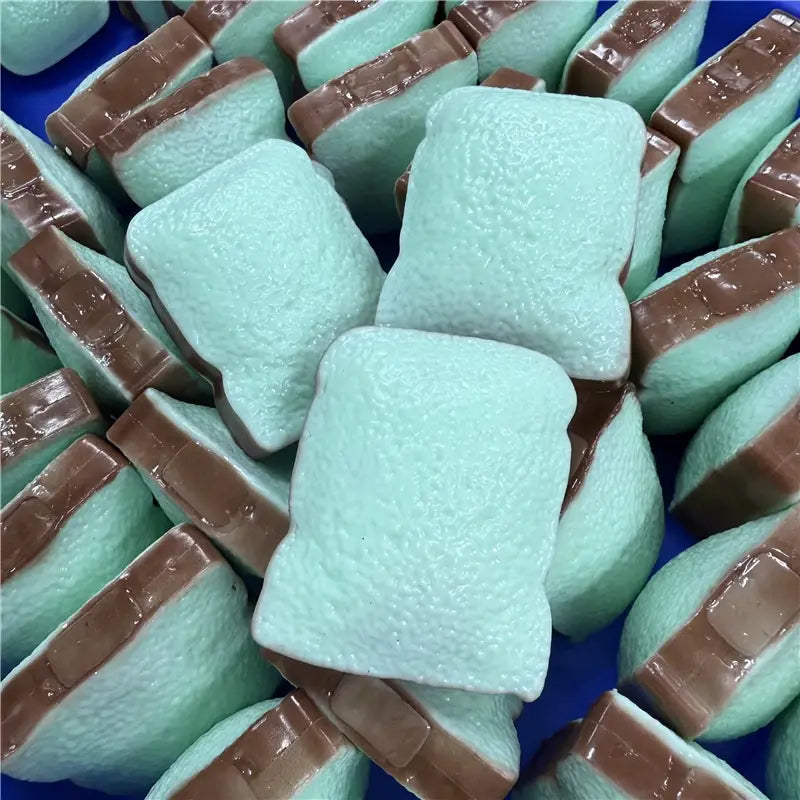 Butterstick als ASMR-Sensory-Squishy-Spielzeug mit mintgrünen rechteckigen Marshmallow-Kandies mit glänzender Schokoladenfüllung.