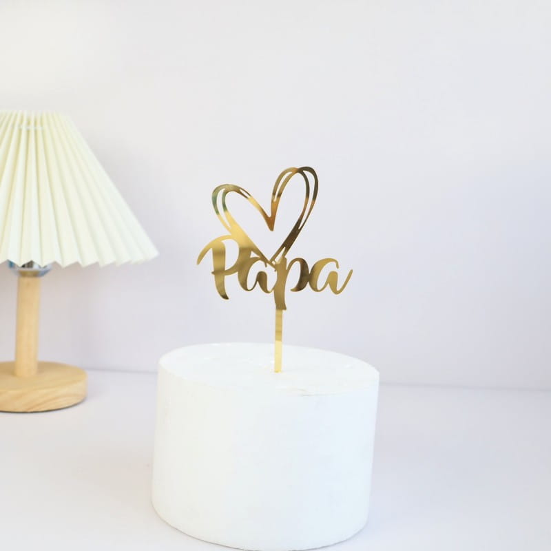 Gold metallic acrylic Father’s Day cake topper featuring the word papa and a heart design for super dad celebrations.