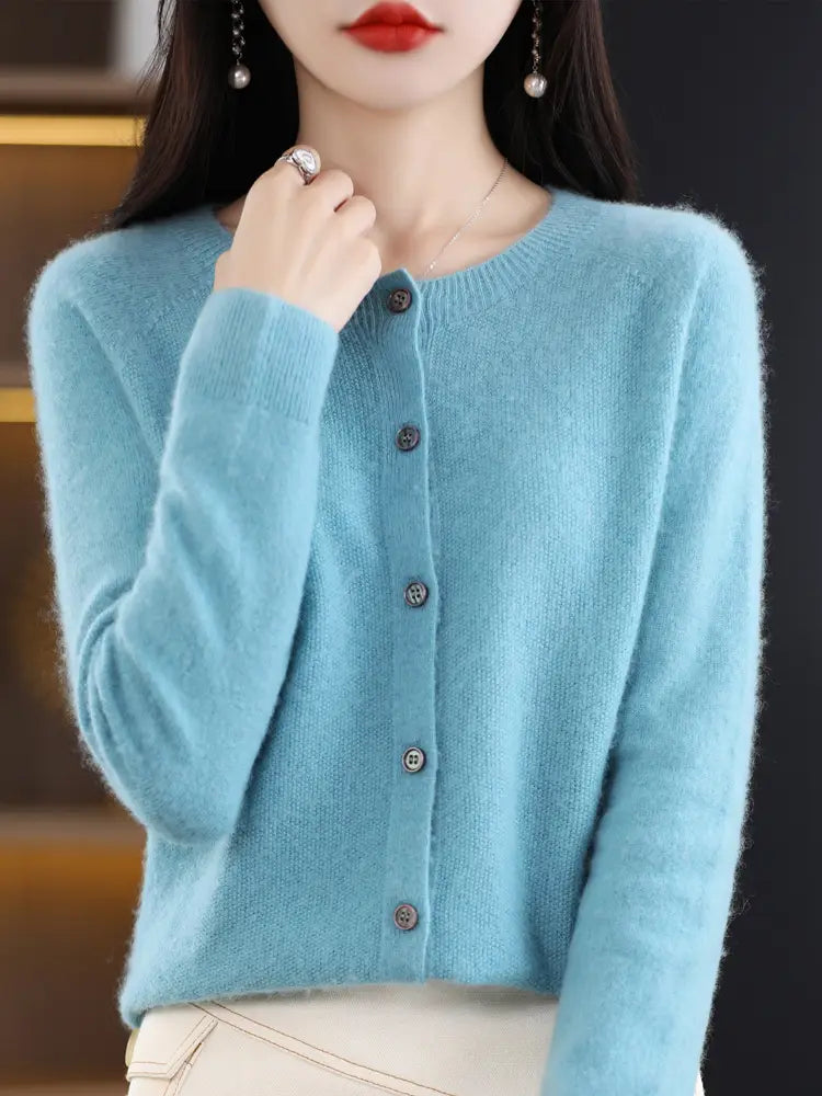 A soft light blue merino wool and cashmere knit cardigan for women featuring a round neckline and five dark buttons down the front.
