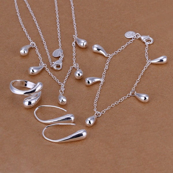 ensemble de bijoux de mariage goutte de larmes en argent 925 comprenant des chaînes délicates, une bague au design entrelacé et des boucles d’oreilles assorties.