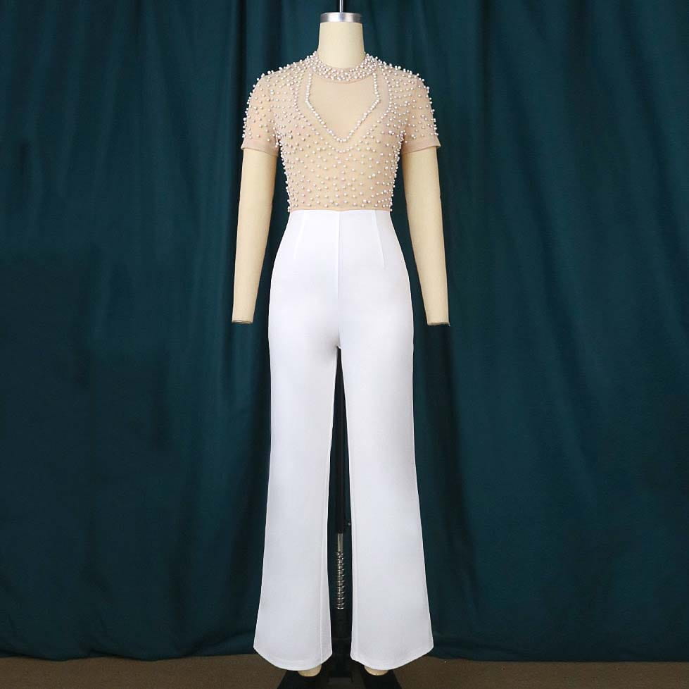Beige beaded mesh jumpsuit with short sleeves and v-neckline paired with high-waisted white wide-leg trousers for a high waist party outfit.