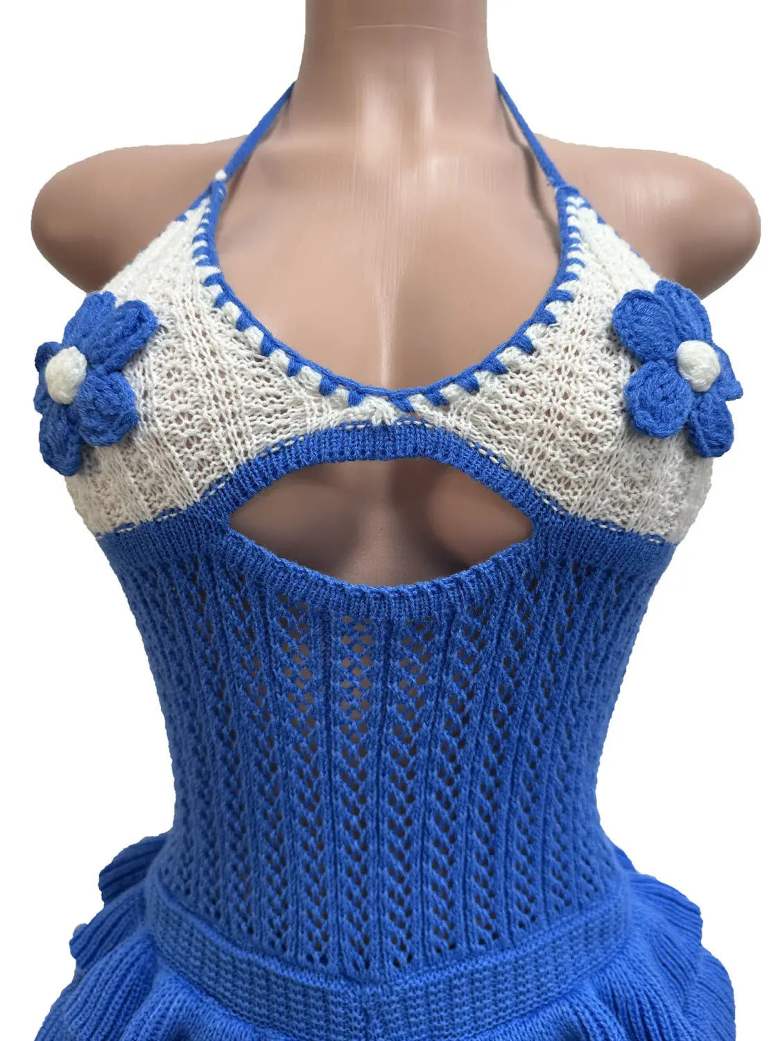 A blue and white knitted halter top with floral embellishments featured in a knitted ruffle halter romper summer playsuit.
