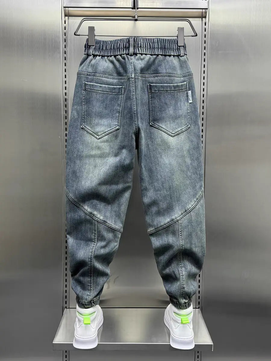 Herren Loose-Fit-Haremhosen aus Denim mit Jogger-Stil in grauem Denim, mit entspannter Passform, elastischem Bund und neongrünen Kordelabschlüssen.