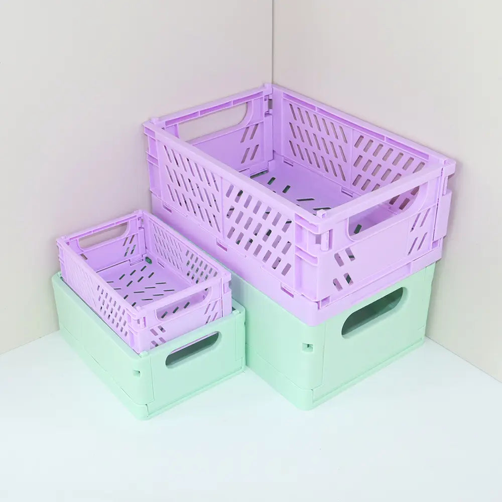 Lila und mintgrüne faltbare Kunststoff-Aufbewahrungsboxen mit Seiten im Rauten-Muster, ausgelegt als pastellfarbene Desktop-Organizer.