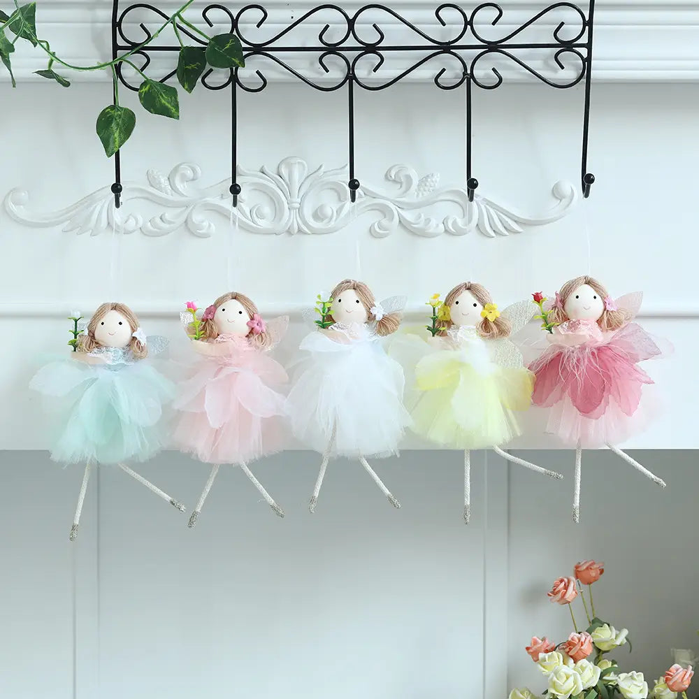 Fünf zarte Oster-Feenfiguren in weichen Pastell-Tüllröcken, die kleine Blumen halten, hängen anmutig an einem dekorativen schwarzen schmiedeeisernen Gestell und sind Teil eines Oster-Feen- und Osterhasen-Anhängesets.