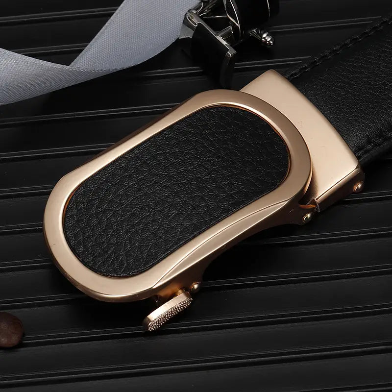 Un cinturón de cuero con hebilla automática de tono dorado rosado, elegante y con inserto de cuero negro texturizado y bordes cosidos a juego, para hombres informales.