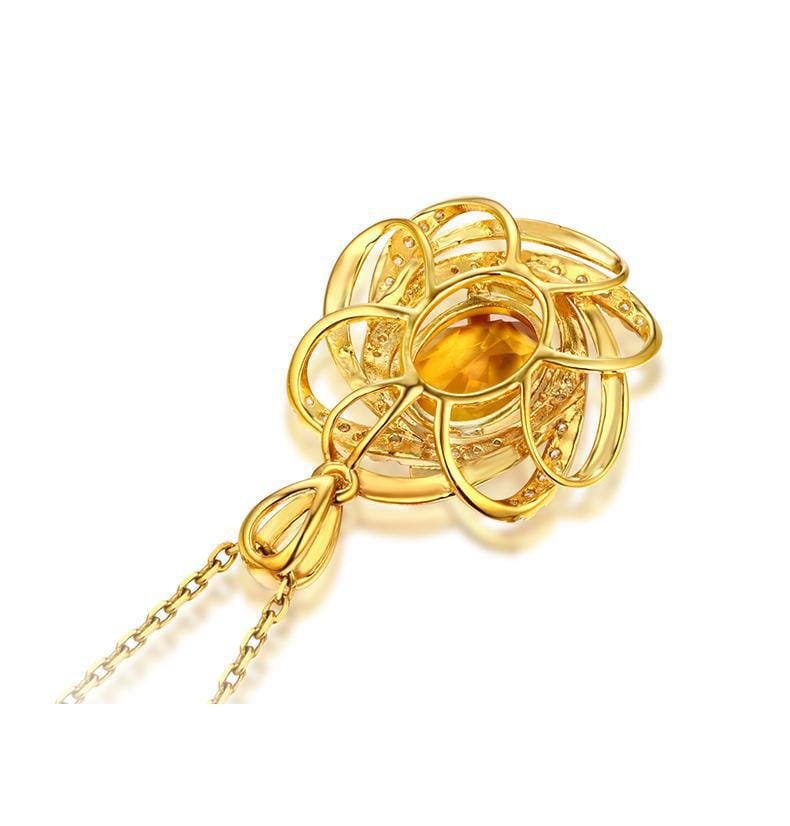 Collier pendentif doré en forme de fleur, moulin à vent en citrine, comportant une pierre ambre centrale et un motif d’entrelacs complexe sur une chaînette dorée délicate.