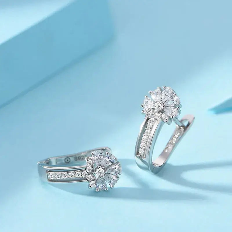 Pendientes de flores de circonio en plata de ley con un diseño de diamantes tipo pavé y una banda moderna y elegante.