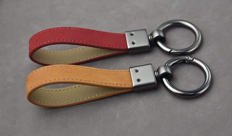 Leather keychains set featuring red and tan leather with silver-toned metal rings and multicolor metal clasps.