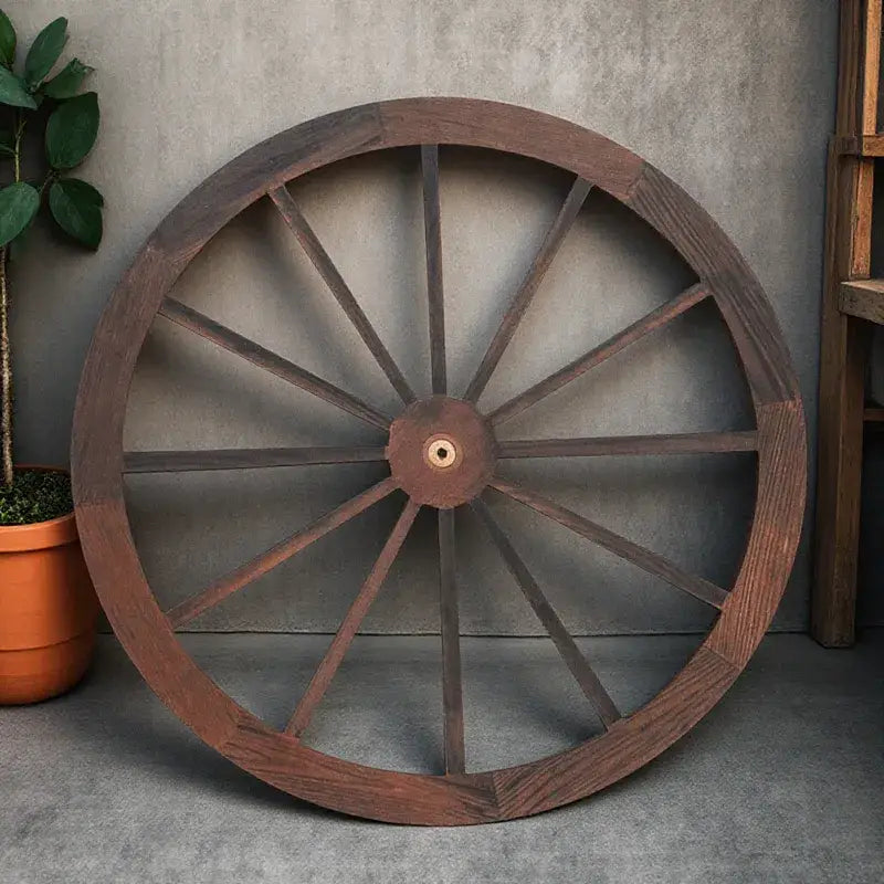 Eine rustikale Wanddekoration aus einem hölzernen Wagenrad mit dunkler brauner Holzoptik, mit zentraler Nabe und radial verlaufenden Speichen.