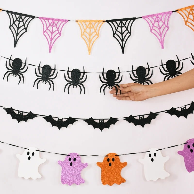 Guirnalda decorativa de papel con purpurina para Halloween que presenta una guirnalda con arañas negras y formas brillantes de murciélagos y fantasmas de araña, para una decoración festiva.