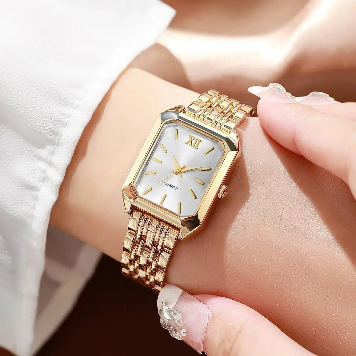 Women gold rectangle quartz watch with white dial roman numeral hour markers and elegant mesh strap.