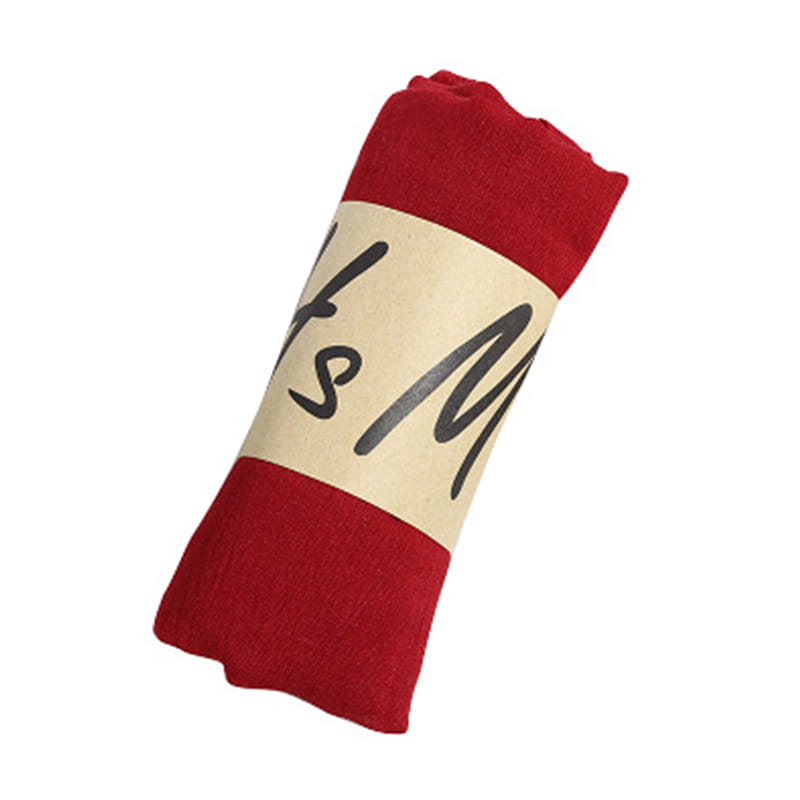 Red cotton winter scarf for women with a solid warm fabric and a beige label featuring black cursive text.