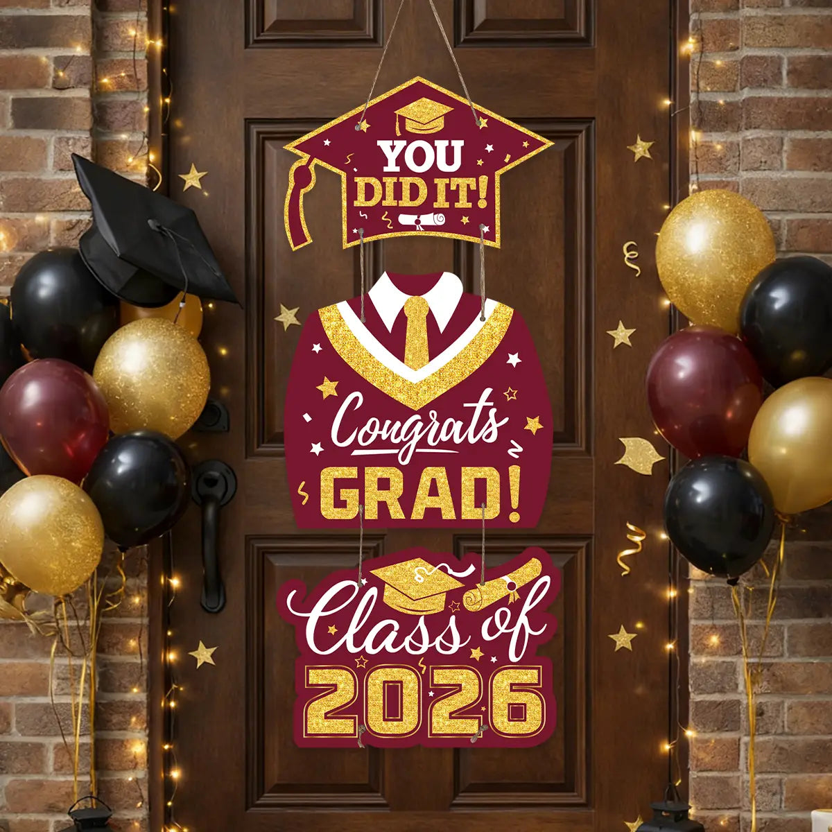A maroon and gold class of 2026 graduation door hanging decor made of glittery material featuring a cap design with you did it and a vest graphic with congrats grad text.