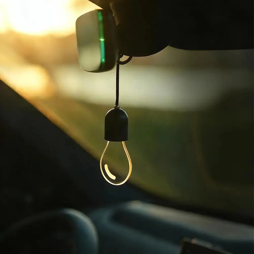 Ampoule LED décorative élégante noire, en forme d’ampoule suspendue, diffusant une illumination jaune chaleureuse, conçue pour l’éclairage d’ambiance et alimentée par des piles bouton CR2032.
