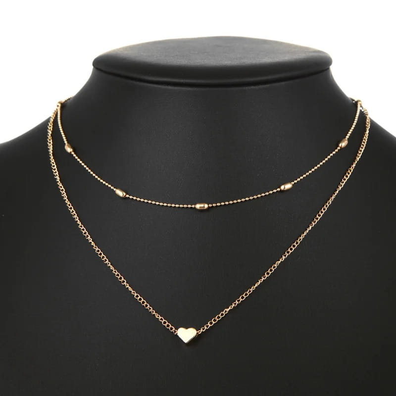 Gold-toned layered heart pendant necklace for women featuring delicate alloy jewelry chains with small oval beads and a single heart pendant, recommended to avoid contact with warm water.