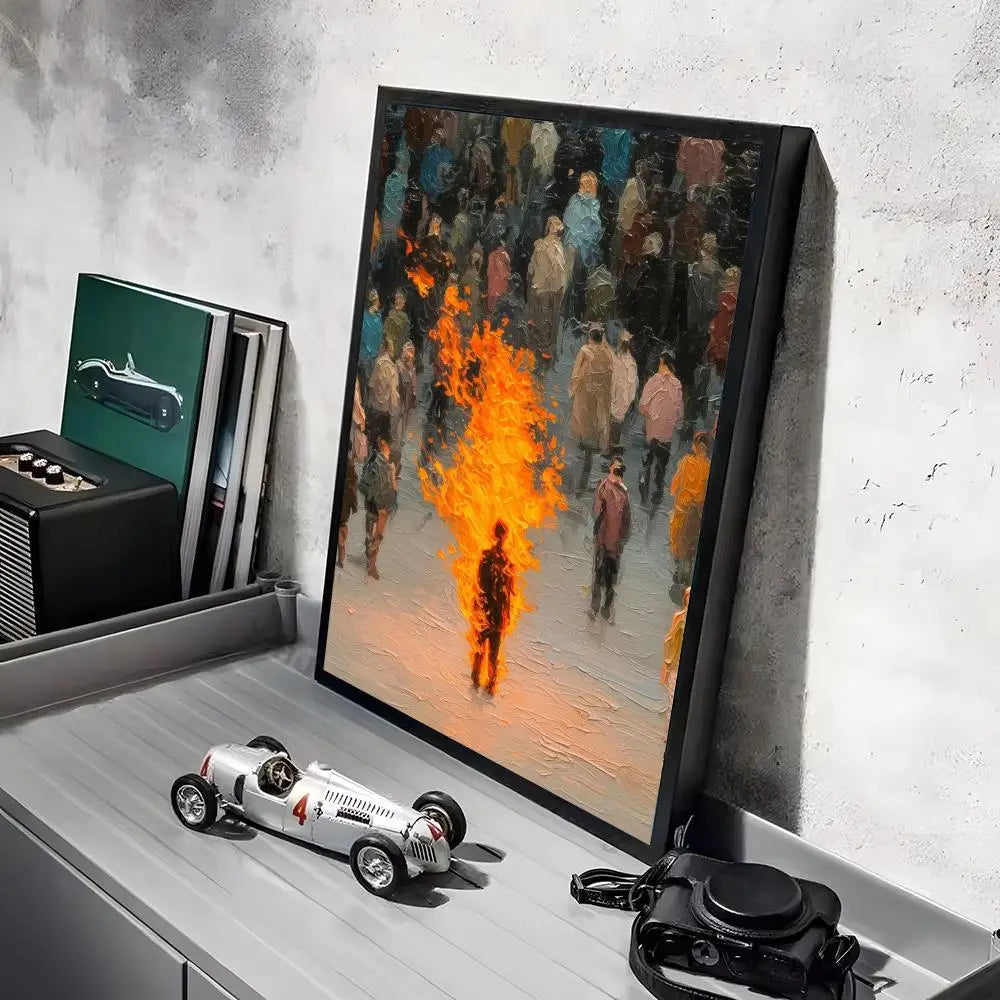 Black-framed canvas print featuring minimalist aesthetics with a modern graphic of a crowd and a central figure engulfed in vibrant orange flames ideal for living room decor.