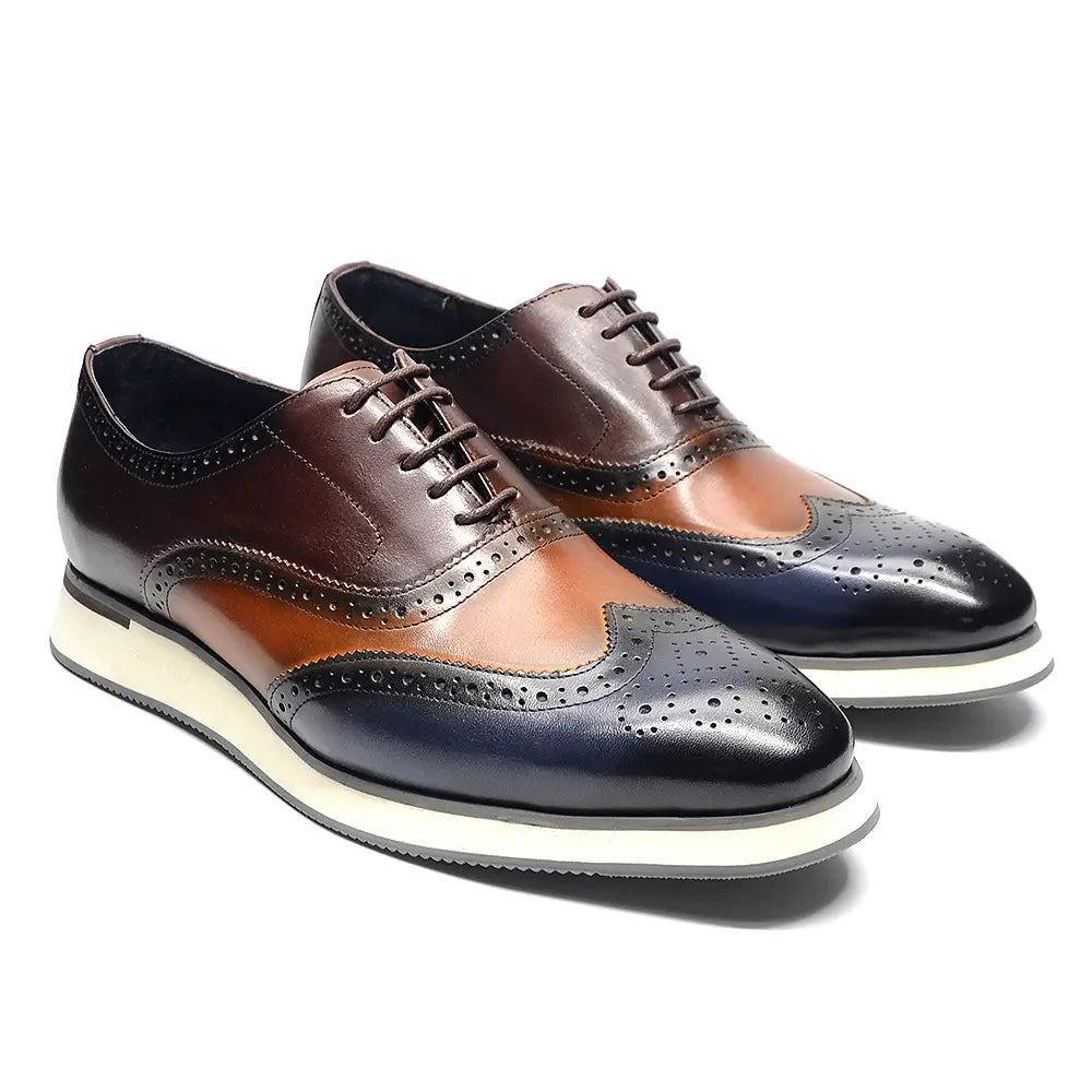 Escarpins brogue wingtip en cuir marron et bleu marine bicolore, avec une semelle en caoutchouc blanc.