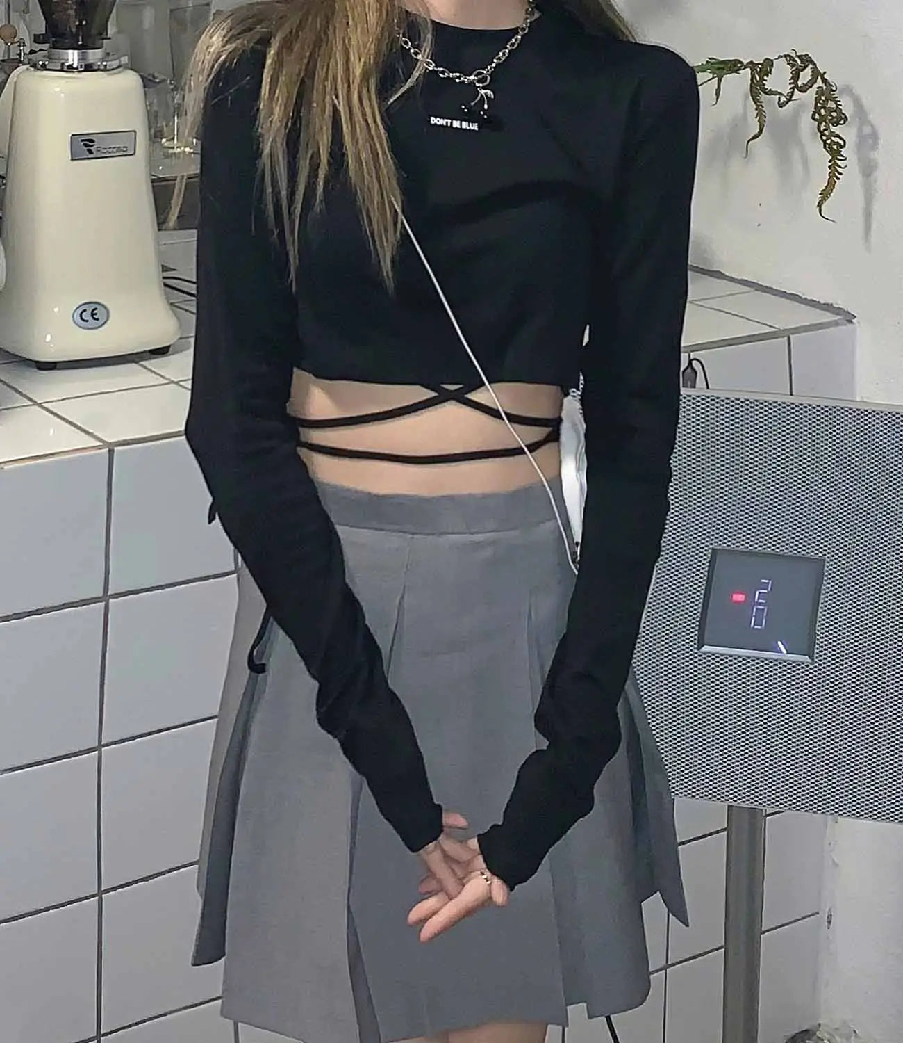 Schwarzes Langarm-Crop-Top aus weichem Stoff mit Crisscross-Detail am Taillenbereich für Damen.