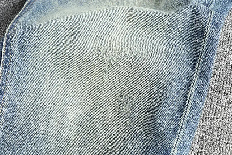 jeans en denim ample à broder pour hommes en denim clair, avec un délavage subtil et des empiècements d’aspect usé