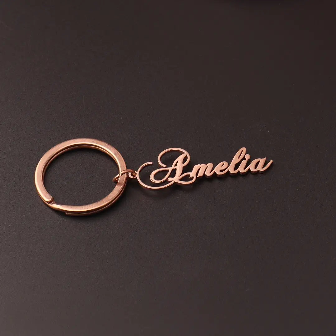 Rose gold-colored custom name keychain featuring the name amelia in elegant cursive script made of stainless steel ideal as a personalized gift.