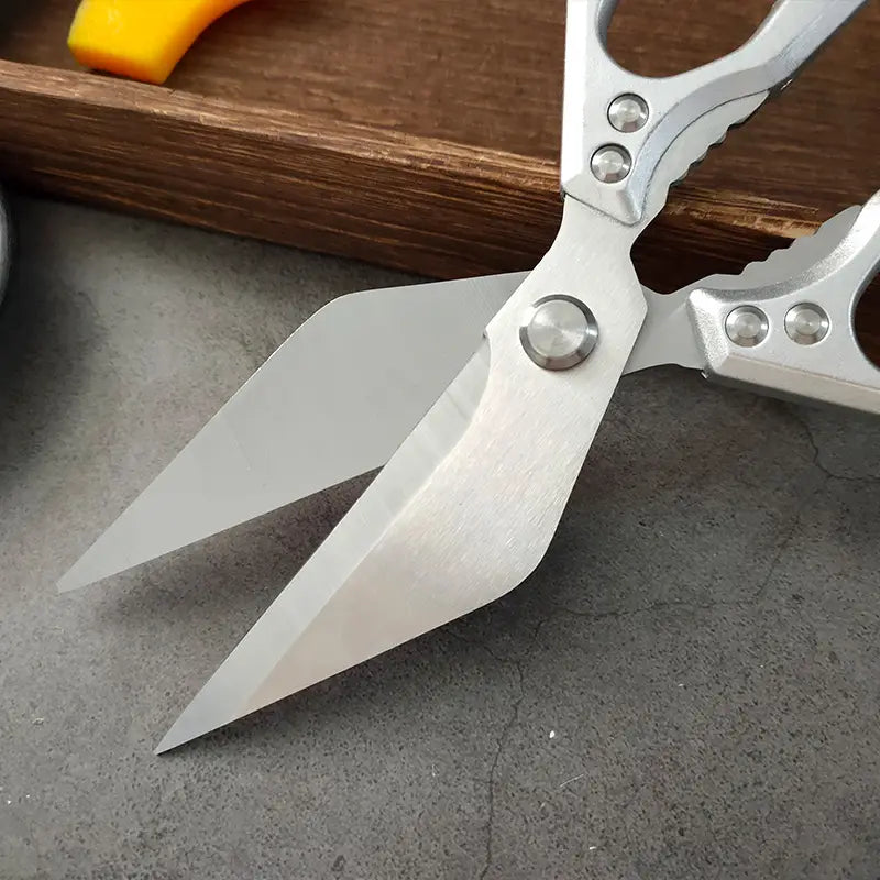 Edelstahl-Multifunktionsküchenscheren mit silberfarbener, gebürsteter Metalloberfläche und ergonomischen Griffen mit kreisförmigen Nieten.