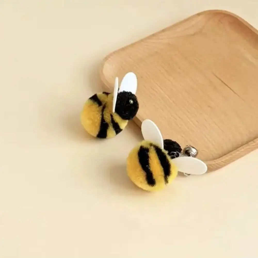 白いプラスチック製の翼を備えた、かわいらしい黄と黒の毛むくじゃらのハチのイヤリングで、猫おびき寄せ玩具のぬいぐるみ用インタラクティブなおもちゃのタイプとして設計されたもの。