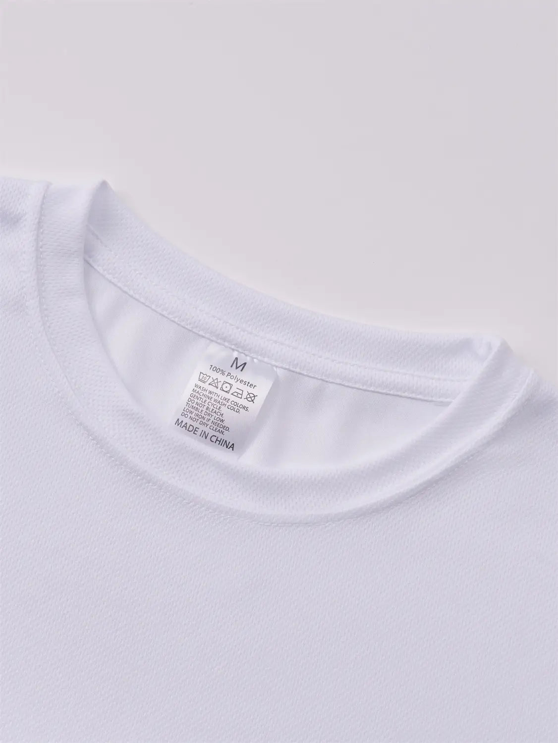 T-shirt d’été pour homme Nautica en coton blanc, imprimé graphique en lettres, avec un col ras simple et étiquette d’entretien indiquant « Fabriqué en Chine ».