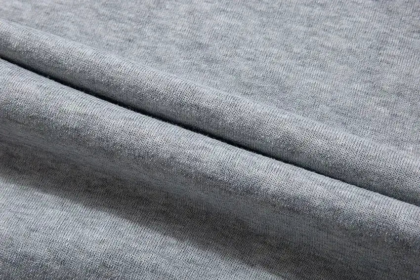Weicher melierter Graustoff in Strickoptik mit glatter Oberfläche und dezenter Rippenstruktur, der im Stussy-Graffiti-Pullover mit Kapuze für lässige Herrenbekleidung verwendet wird.
