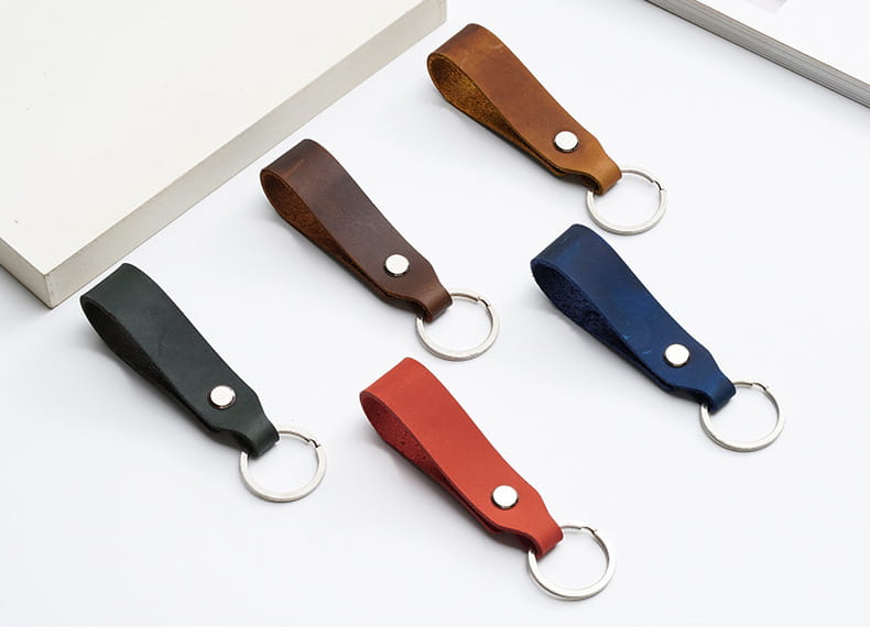 Set of five genuine leather car keychains in black brown red and navy blue with silver-toned metal rings for use as lanyard key holders.