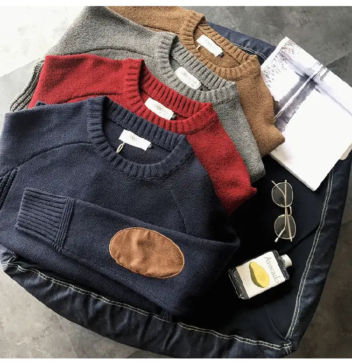 pull en laine pour homme surdimensionné couleur bleu marine, avec patch au niveau du coude marron et poignets côtelés, conçu comme une maille décontractée surdimensionnée.