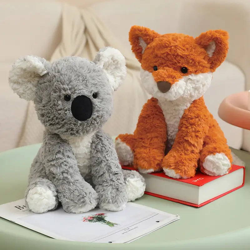 soft gray koala plush stuffed animal toy with white accents and black nose sitting beside an orange fox plush toy measuring 25cm