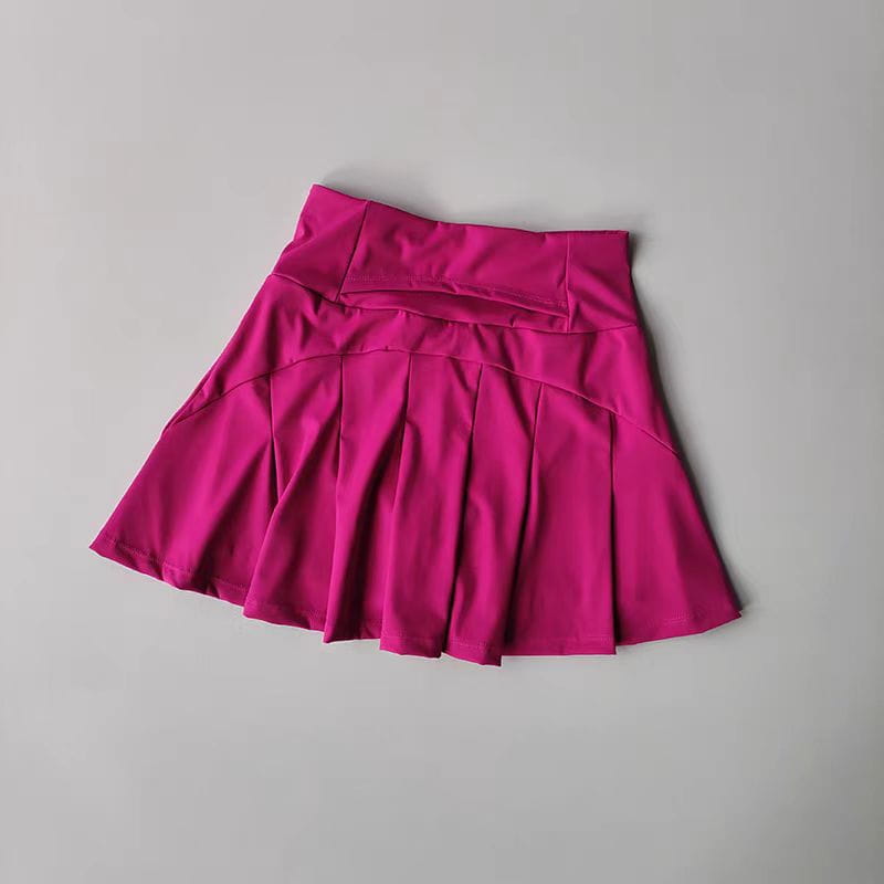 Ein kräftiger fuchsiafarbener High-Waist-Sport-Tennisrock aus glattem, elastischem schnelltrocknendem Stoff mit plissiertem Design.