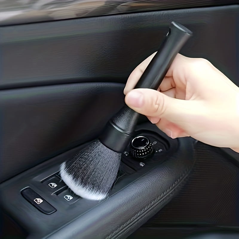 Detailreinigungsbürste für den Innenraum eines schwarzen Fahrzeugs mit dichten weichen Borsten und einem eleganten Griff für eine präzise Reinigung.