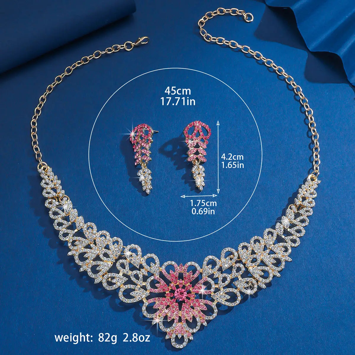 Un collier à la finition ton or au motif floral complexe et aux ornements en cristaux roses et clairs étincelants, dans l’ensemble de bijoux en forme de fleur en cristal rose plaqué or.