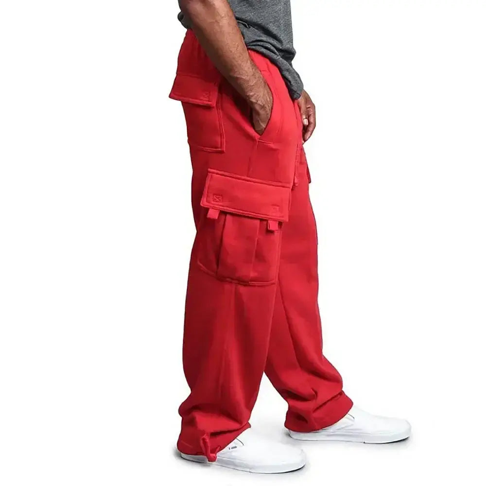 Pantalons cargo rouges pour homme, avec plusieurs poches et une coupe ample, réalisés à partir d'un tissu confortable de jogging, adaptés à un usage décontracté.
