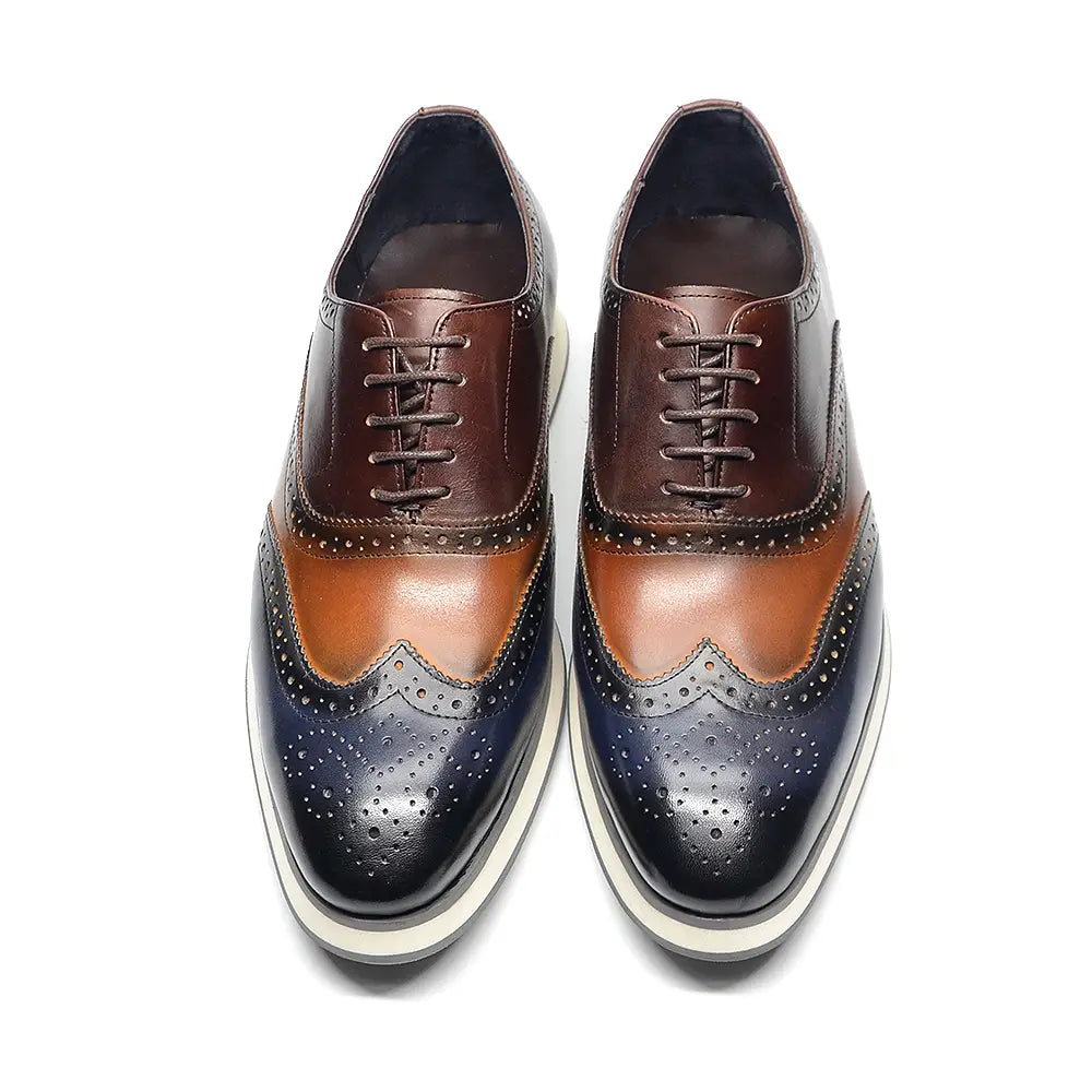 Escarpins brogue Oxford wingtip bicolores marron et bleu marine en cuir, avec des détails ajourés.